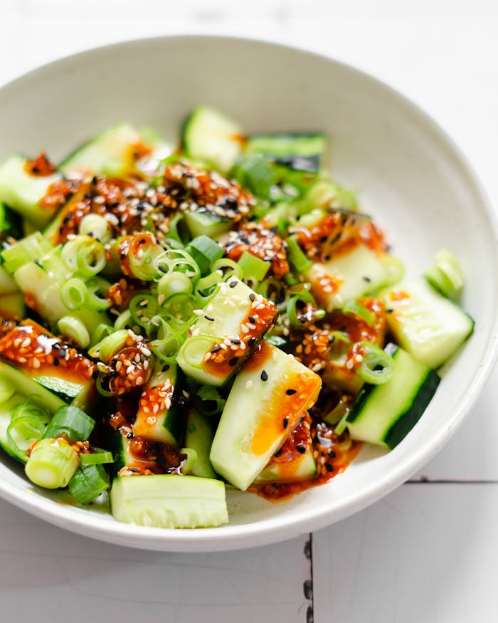 Fresh cucumber salad topped with spicy sesame sauce for a zesty, healthy appetizer.