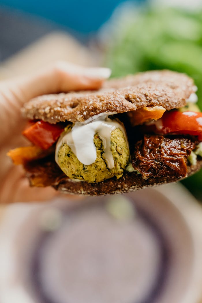 Close-up of a vegan falafel sandwich with fresh veggies, perfect for a healthy meal.